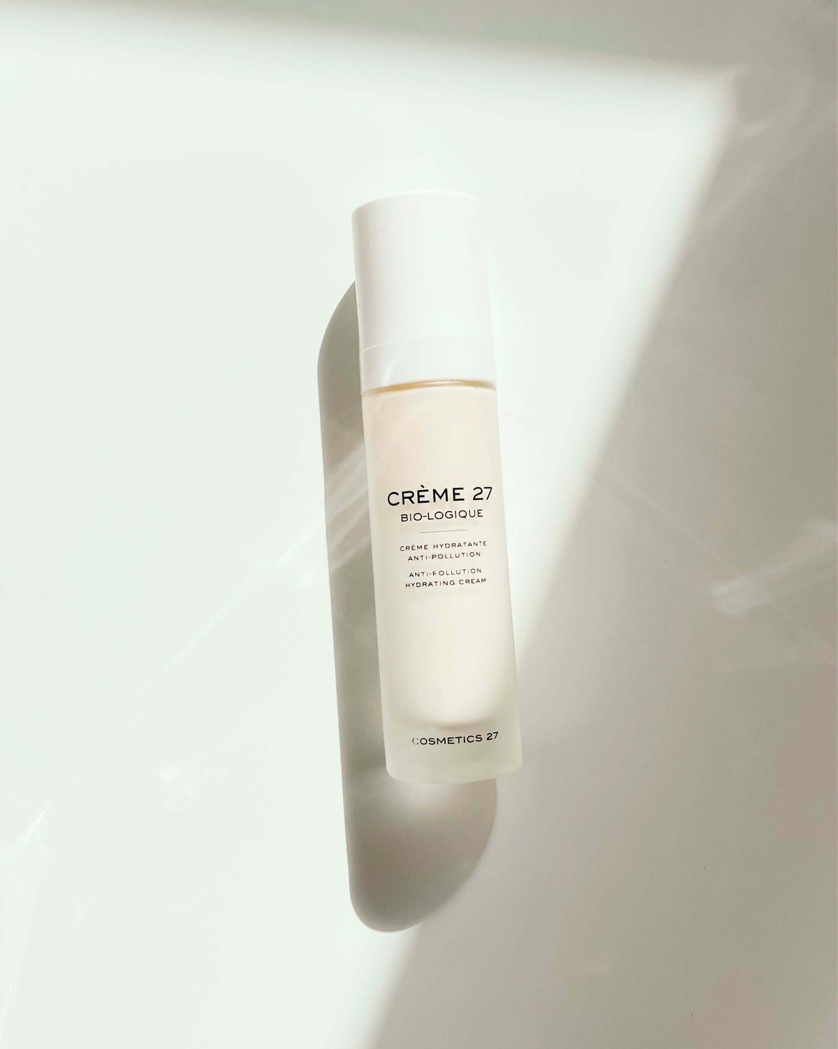 Crème 27 Bio-logique bottle lying in a shaft of light, seen from above