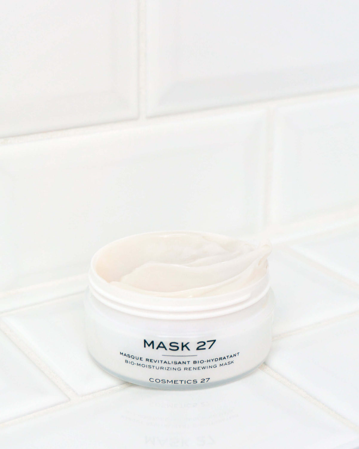 Pot ouvert de Mask 27 rempli de crème, posé sur un carrelage blanc