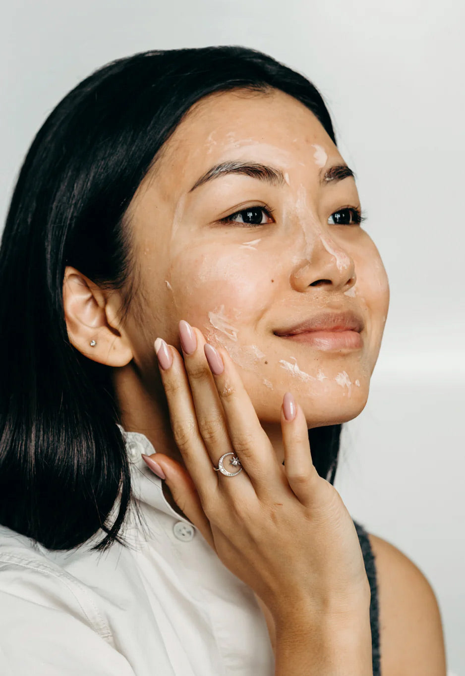Smiling woman massaging the cleansing balm over her face