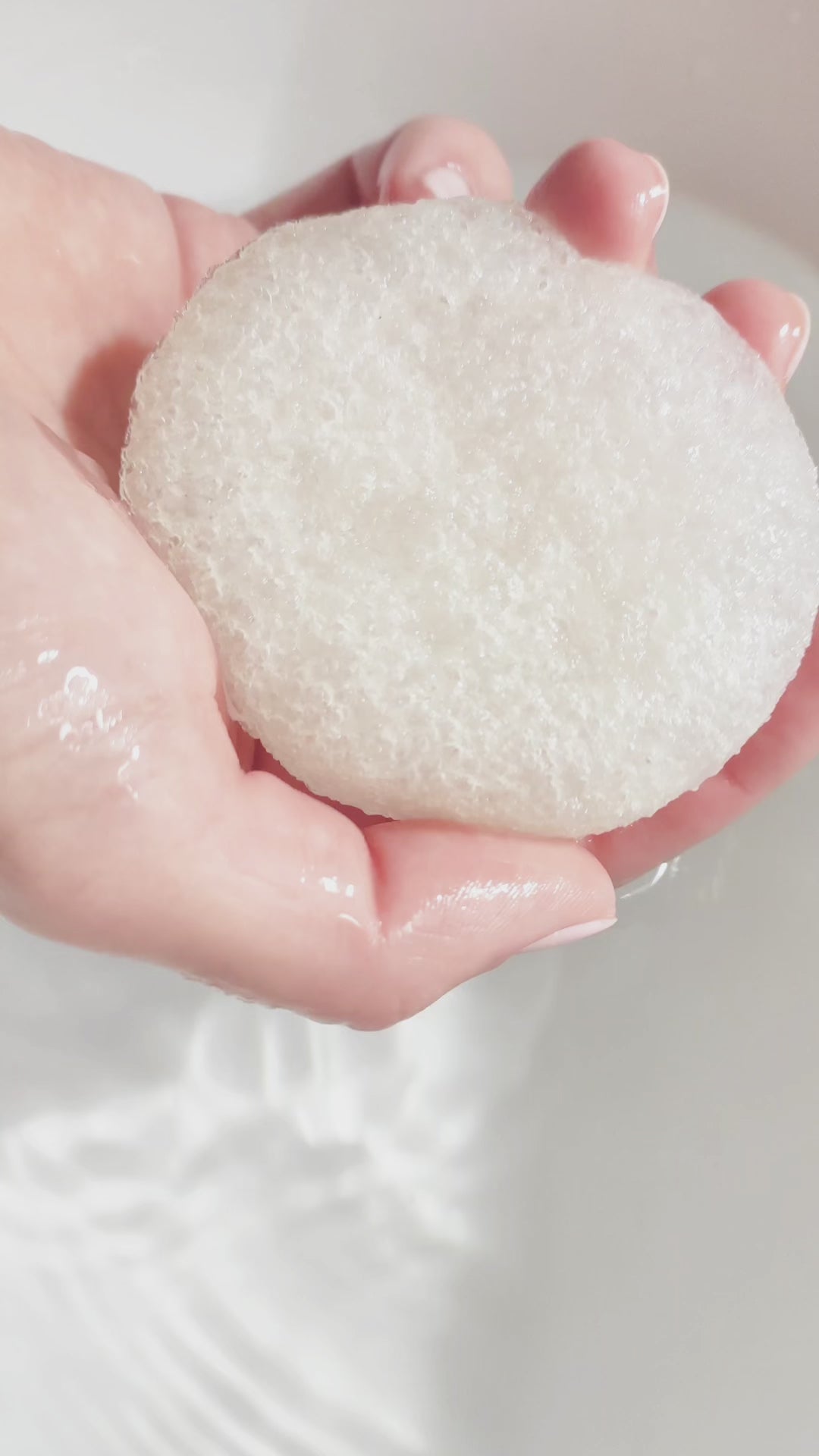 Vidéo : mains pressant une éponge Konjac gorgée d'eau